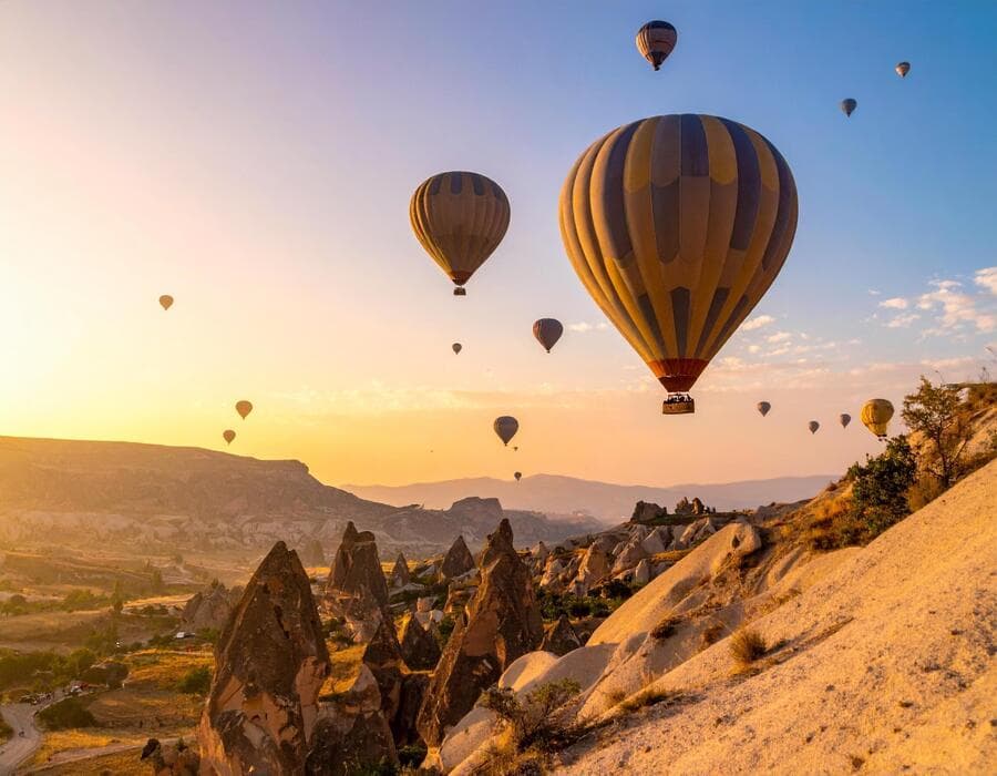 Hot air balloons drifting over desert rock formations