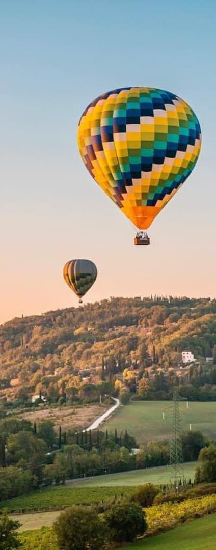 Hot air balloon over misty hills at sunrise